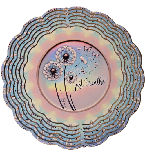 Decorative plate with dandelion design and 'just breathe' text on a colorful background